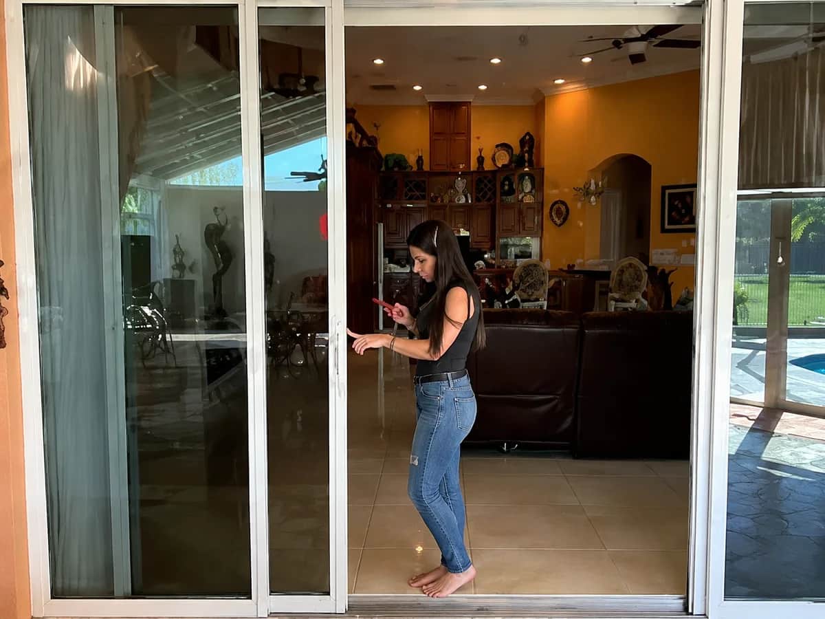 The same door sliding open under one finger placed against the handle